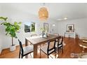 Bright dining room featuring hardwood floors, a unique chandelier, and ample natural light at 4720 Perry St, Denver, CO 80212