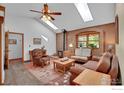 Bright and inviting living room with a brick fireplace, skylights, hardwood floors, and comfortable seating at 623 Mead Ct, Louisville, CO 80027