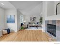 Spacious living room featuring hardwood floors, a cozy seating area, and a tiled fireplace at 651 Ridgeview Dr, Louisville, CO 80027