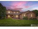 Attractive two-story home with stone accents, covered front porch, and a dramatic sunset backdrop at 6544 Saddleback Ave, Longmont, CO 80504