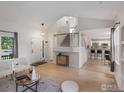 Open-concept living room with hardwood floors, bright windows, and a view of the staircase and kitchen at 707 Starkey Ct, Erie, CO 80516