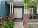 Inviting front porch with brick pillars and white trim, leading to the main entrance of the home at 707 Starkey Ct, Erie, CO 80516