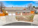 Quaint brick ranch home with a two-car garage and a circular driveway at 7162 Quay St, Arvada, CO 80003
