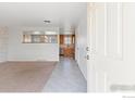 Open-concept living area leading to a kitchen with stainless steel appliances at 7162 Quay St, Arvada, CO 80003
