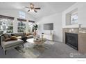 Bright living room featuring a vaulted ceiling, fireplace, and abundant natural light from large windows at 729 Snowberry St, Longmont, CO 80503