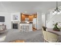 Open-concept living space featuring a kitchen, fireplace, and dining area at 729 Snowberry St, Longmont, CO 80503