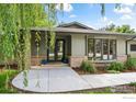 Welcoming front porch of a single-story home, featuring double glass doors and stylish brick accents at 7720 Ferris Way, Boulder, CO 80303