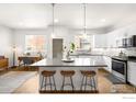 Modern kitchen with white cabinets, a large island, and stainless steel appliances at 883 Widgeon Cir, Longmont, CO 80503