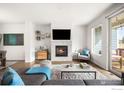 Bright living room with fireplace, neutral decor, and a sliding door to outdoor space at 883 Widgeon Cir, Longmont, CO 80503