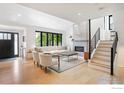Open living space features a modern fireplace, large windows, and a view of the staircase with contemporary design at 950 Quince Ave, Boulder, CO 80304