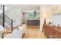 Bright open concept living room shows stylish decor and transitions to the kitchen with hardwood flooring and a staircase at 950 Quince Ave, Boulder, CO 80304
