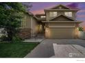 Charming two-story home with stone accents, a two-car garage, and a well-maintained front yard at 9673 Roadrunner Ave, Firestone, CO 80504