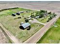 An aerial shot reveals a farm with outbuildings, silos, and a residence, highlighting the property's infrastructure at 0 Tbd E 112Th Ave, Bennett, CO 80102
