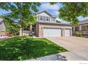 Inviting home exterior with a spacious three-car garage, lush green lawn, and a cozy front porch at 11861 Fairplay St, Commerce City, CO 80603