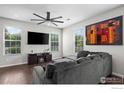 Cozy living room featuring modern ceiling fan, large TV, and comfortable sectional sofa at 12724 Leyden St # E, Thornton, CO 80602