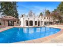 A luxurious white house with a stunning pool that reflects the blue sky above at 2111 E Alameda Ave, Denver, CO 80209