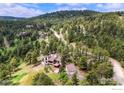 An aerial view of the house, garage, and landscaping in a beautiful wooded area at 2794 Linden Dr, Boulder, CO 80304