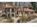 Charming home with a stone exterior, red tile roof, manicured lawn, and a welcoming pathway at 2111 E Alameda Ave, Denver, CO 80209