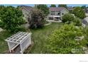 Lush backyard with mature trees, pergola, and patio, perfect for outdoor entertaining at 3545 Cottonwood Cir, Frederick, CO 80504