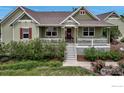 Charming home featuring a welcoming front porch, decorative shutters, and lush landscaping at 3545 Cottonwood Cir, Frederick, CO 80504