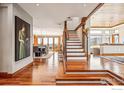 Bright entryway with hardwood floors, wooden stairs, and an open floor plan at 3875 Cloverleaf Dr, Boulder, CO 80304