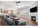 Open-concept living room featuring a fireplace, a TV, and an over-sized gray sectional at 4600 Shady Path Ln, Castle Rock, CO 80104