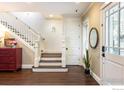 Bright foyer with hardwood floors, staircase, and decorative mirror, creating a welcoming entry at 512 Marine St, Boulder, CO 80302