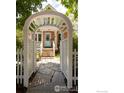 Inviting entrance featuring a charming white arbor gate and stone pathway leading to the front door at 512 Marine St, Boulder, CO 80302