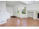 Bright living room featuring hardwood floors, fireplace, and large windows at 5190 Buckingham Rd, Boulder, CO 80301
