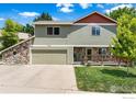 Two-story home featuring stone accents, a two-car garage, and well-maintained landscaping against a blue sky at 602 S 9Th St, Berthoud, CO 80513