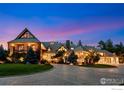 Beautiful exterior view of the home at dusk, showcasing architectural details and manicured lawn at 6917 Timbers Dr, Evergreen, CO 80439