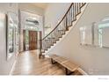 Bright foyer with wood floors, staircase, and high ceilings at 714 Skywalker Pt, Lafayette, CO 80026