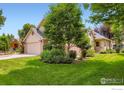 View of a well-maintained single-Gathering home, showcasing its lush lawn, mature trees, and welcoming facade at 7196 Christopher Ct, Niwot, CO 80503
