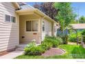 Inviting entrance features a covered porch, beautiful landscaping, and a charming exterior with a serene ambiance at 7196 Christopher Ct, Niwot, CO 80503