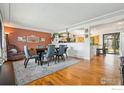 Open concept dining area featuring hardwood floors, stylish decor, and seamless flow into the kitchen at 7423 Saulsbury St, Arvada, CO 80003