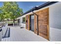 The front door shows a gray painted porch, a wooden accent wall, and a black front door at 7826 Joan Dr, Denver, CO 80221