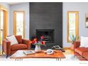 Cozy living room featuring a modern fireplace, hardwood floors, and natural light from large windows at 8323 Thunderhead Dr, Boulder, CO 80302
