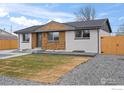 View of the home showcasing a well-kept lawn and updated exterior with modern accents at 9230 Aspen Dr, Thornton, CO 80229