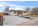 Exterior view of a modern, renovated home with a spacious driveway and detached garage at 9230 Aspen Dr, Thornton, CO 80229
