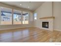Sun-filled living room with hardwood floors, fireplace and large windows showcasing backyard at 961 Eldorado Ln, Louisville, CO 80027