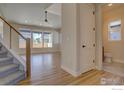 Open concept living room featuring gleaming hardwood floors, big windows, and a view of the stairs at 961 Eldorado Ln, Louisville, CO 80027