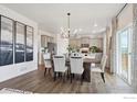 Dining room with chandelier, leading to modern kitchen and outdoor access at 13804 Quartz St, Mead, CO 80504