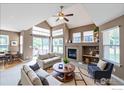 Bright living room features a fireplace, vaulted ceiling, large windows, and neutral decor at 13900 Lake Song Ln # 3, Broomfield, CO 80023