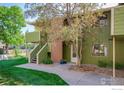 Exterior shot of the home with a brick facade and mature tree in the front yard at 1410 Bacchus Dr # B12, Lafayette, CO 80026
