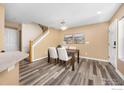 Dining room featuring modern lighting, wood floors, neutral color scheme, and staircase access at 14246 Pikeminnow Pl, Broomfield, CO 80023