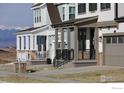 View of two homes with mountains in the background, showing covered entry porches and well-maintained landscaping at 1571 Poplar Dr, Erie, CO 80516