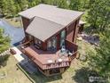 Aerial view showcasing a brown cabin featuring a sprawling wooden deck and outdoor furniture at 173 Silver Cloud Ln, Boulder, CO 80302