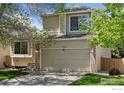 Traditional home featuring a spacious garage, well-kept lawn and large window providing natural light at 17611 Hoyt Pl, Parker, CO 80134