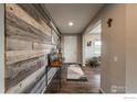 Welcoming entryway features hardwood floors, a textured accent wall, and a cozy rug at 1910 High Plains Dr, Longmont, CO 80503