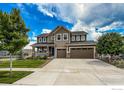 Attractive two-story home with a spacious driveway, a manicured lawn, and a cozy front porch at 1910 High Plains Dr, Longmont, CO 80503